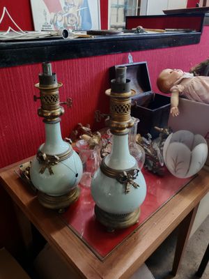 trois vases posés sur une table, avec une poupée en arrière-plan