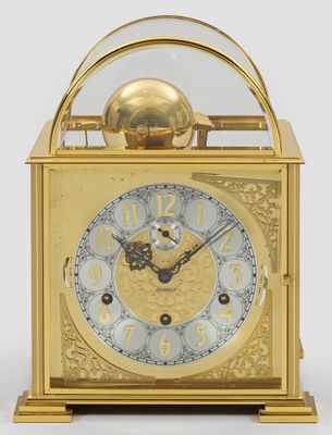 une horloge en or surmontée d'un dôme en verre