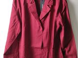 red jacket hanging on a hanger against a white wall