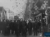 photographie en noir et blanc d'une foule de personnes debout dans une rue