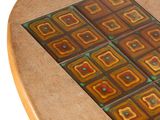 a close up of a wooden table with a tile design on it