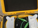 a yellow case with a green and black patch cable in it
