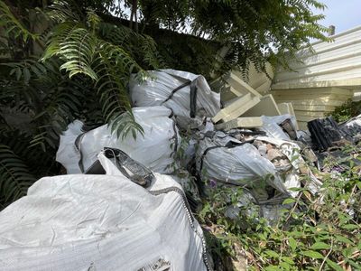 un tas d'ordures par terre, à côté d'un immeuble