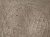 a picture of a face drawn in the sand on the beach