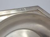 a silver plate on a table with a white background