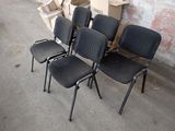 four black chairs sitting in front of a brick wall