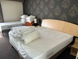 two beds in the room with white sheets on them
