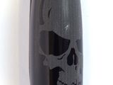 a black pen with a skull on it on a white surface