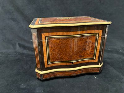 une petite boîte en bois ornée d'un motif décoratif sur le devant