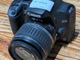 a camera sitting on a wooden table with a lens attached to it