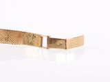 an image of a gold bracelet on a white surface