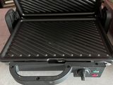 a grill that is sitting on the floor next to a car