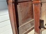 a bed with a wooden headboard and foot board in front of a house