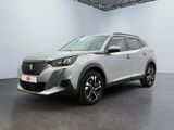 un SUV argenté garé dans une pièce blanche au sol noir