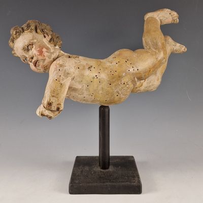 statue représentant un bébé allongé sur le dos sur un socle noir