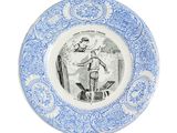 a blue and white plate with a drawing of a man on a surfboard