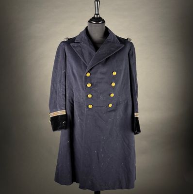 a blue coat with gold buttons on a mannequin stand