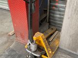 a forklift with a pallet attached to it in front of a garage