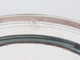 a silver plate with a silver handle on a white table