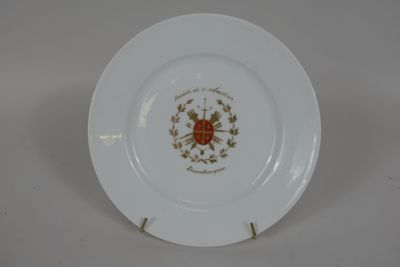 une assiette blanche ornée d'un motif doré et rouge
