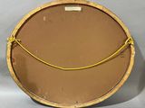 a round mirror with a yellow rope around it