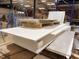 several stacks of white sheets of paper stacked on top of each other in a warehouse