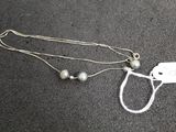 a silver necklace with a tag attached to it