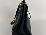 a black leather handbag with gold hardware on the handle