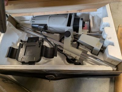 a box with a drill and other tools inside of it