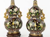 paire de vases ornés de motifs floraux, posés sur des socles, sur fond blanc