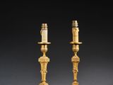 pair of antique brass candlesticks with candles on each of them