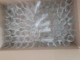 a cardboard box filled with plastic cups and a bunch of toothbrushes