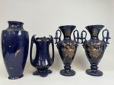 trois vases bleus et un vase sur une surface blanche