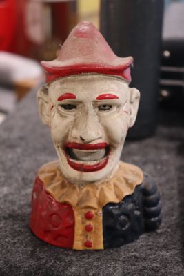 une statue représentant un clown coiffé d'un chapeau rouge