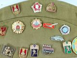 a lot of different badges on a green hat