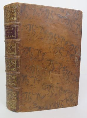 an old book sitting on top of a white surface with writing on it