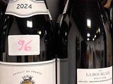 plusieurs bouteilles de vin rouge sont alignées sur une étagère