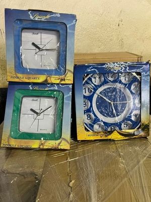 trois boîtes contenant des horloges posées sur une table dans une pièce