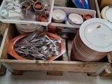 a wooden box filled with plates and bowls on the floor