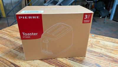 une boîte en carton posée sur une table, contenant un grille-pain