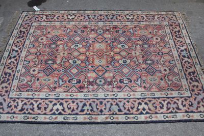 un tapis posé par terre, avec un chat assis à côté
