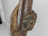 a wooden sculpture of a snake on a white surface
