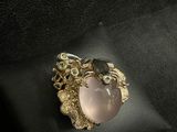 a close up of a gold ring with a pink stone on it