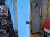 a pile of wood next to a white refrigerator in a room
