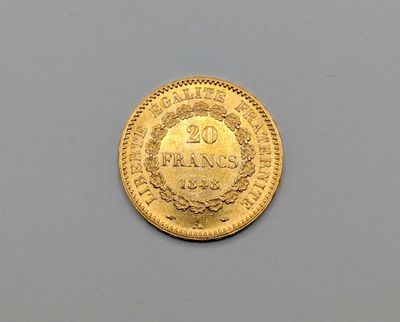 gros plan d'une pièce d'or sur une surface grise