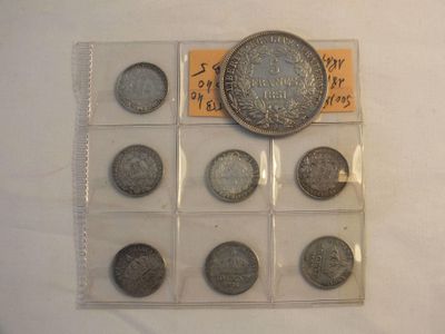 an assortment of chinese coins are displayed in a display case