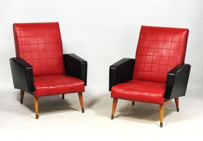 une paire de fauteuils en cuir rouge et noir posés contre un mur blanc