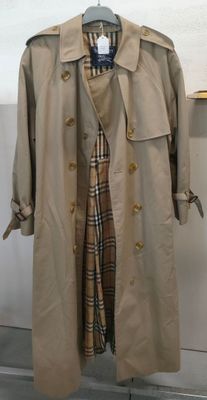 trench coat on a hanger in front of a white wall