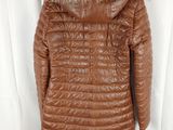 a brown leather jacket with a fur collar on a hanger