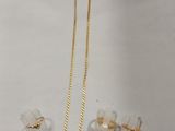 deux colliers en or et une paire de boucles d'oreilles posés sur une table